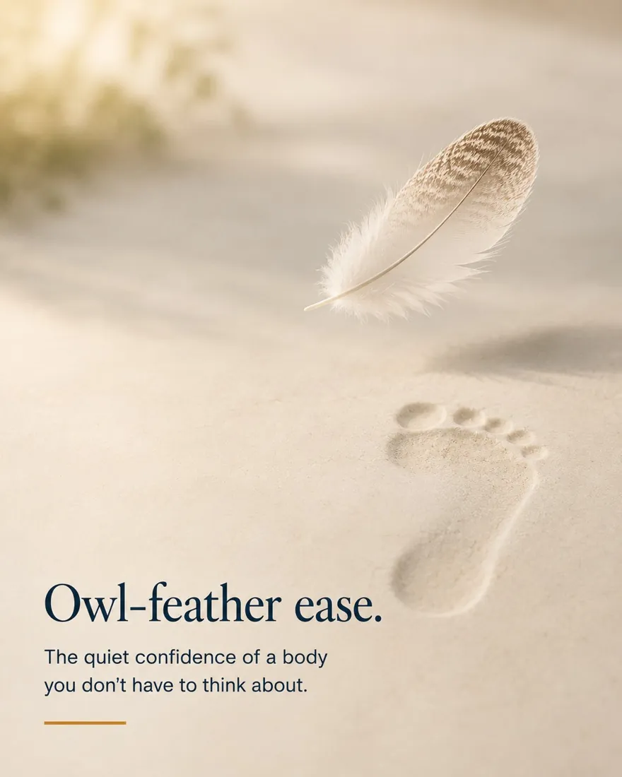 A soft owl feather drifting above a light footprint in sand, evoking quiet, effortless movement.